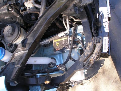 2008 Hyundai Accent - Close-up view of a headlight ballast and associated wiring, showing warning labels and connectors.