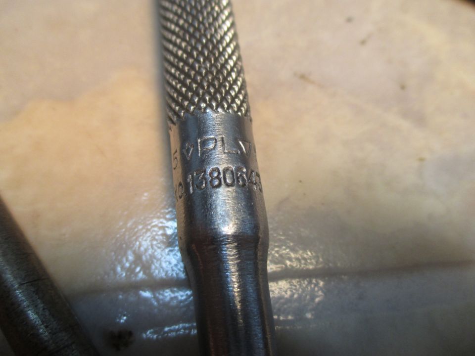 Close-up of a tool handle with knurled grip and stamped markings '5 VPL' and '0138064'