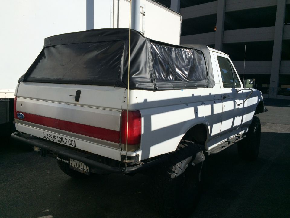 Rear of white lifted Ford SUV with soft top and CLASS8RACING.COM plate