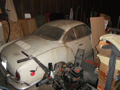 1969 Volkswagen Karmann Ghia - A dusty 1969 Volkswagen Karmann Ghia sits in a cluttered garage, awaiting restoration.