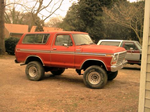 1978 Ford Bronco - This red 1978 Ford Bronco is parked outside next to another vehicle.
