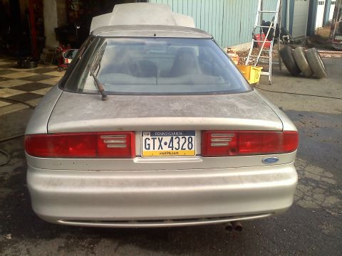 1993 Ford Probe - This 1993 Ford Probe is seen from the rear in a garage setting with its hood up.