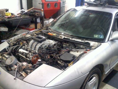 1993 Ford Probe - The engine bay of a silver car is exposed, revealing the V6 engine and surrounding components.