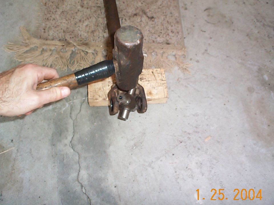 Took a 5 pound sledge hammer, placed the base of the ears on a block of wood, and hit the u-joint.