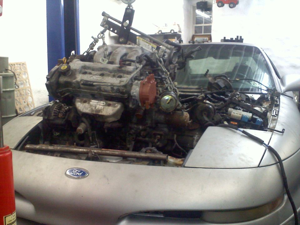 Silver 1993 Ford Probe GT with engine being removed