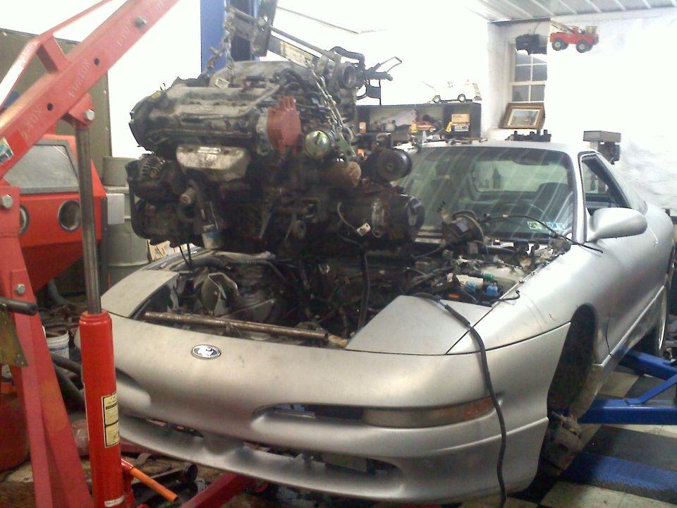 1993 Ford Probe GT with engine being lifted out by a red engine hoist
