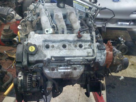 1993 Ford Probe - A Ford engine is shown, suspended by chains, with various components visible including the alternator and distributor.