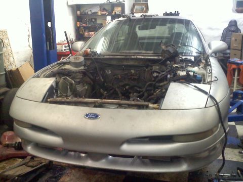 1993 Ford Probe - Front view of a silver 1993 Ford Probe with its hood open, revealing the engine bay in a workshop setting.