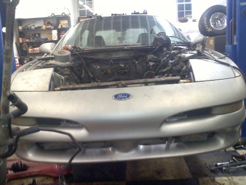 1993 Ford Probe - Front view of a silver 1993 Ford Probe in a garage, with the engine compartment disassembled.