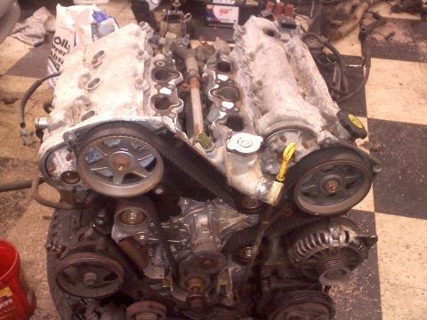1993 Ford Probe - Engine assembly with visible timing belt, pulleys, and alternator. The engine appears to be a V6 configuration.