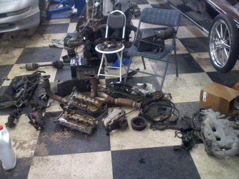 1993 Ford Probe - Various engine components are laid out on the floor, suggesting a repair or rebuild in progress.