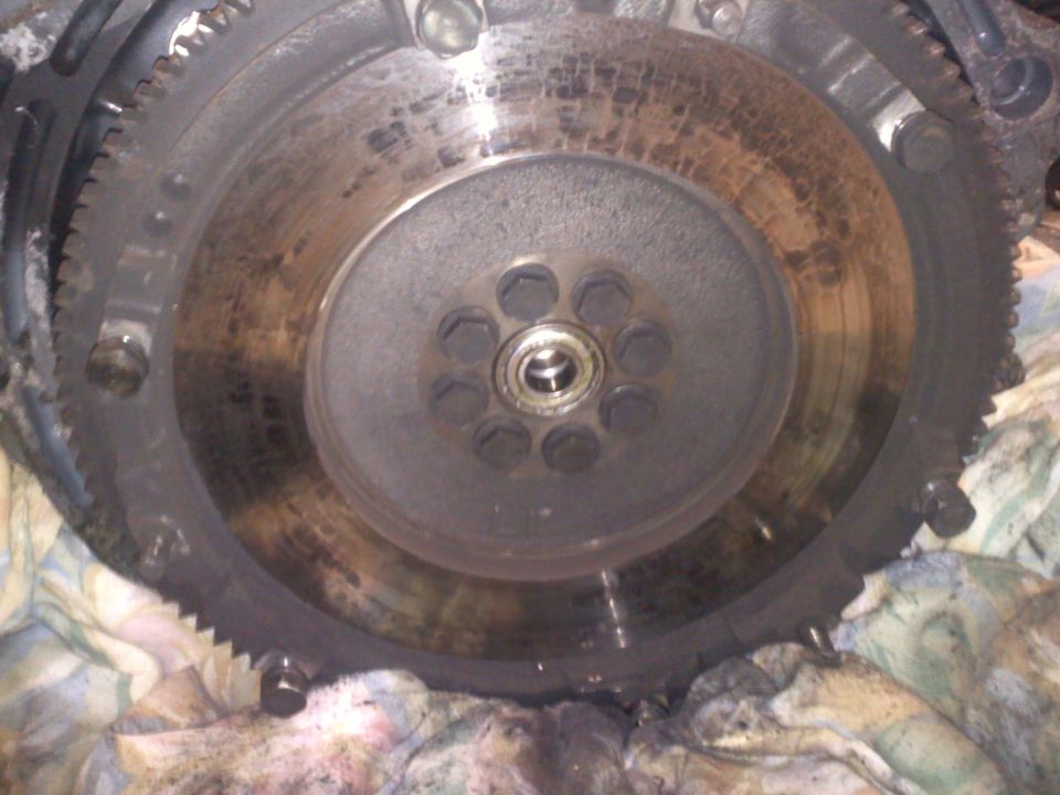 Engine flywheel with visible wear marks and bolt holes
