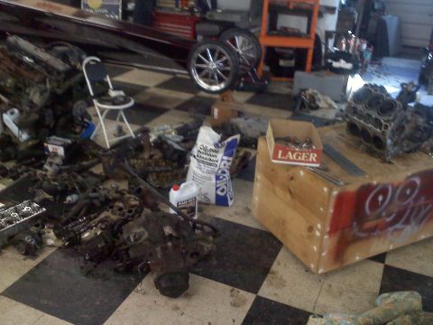1993 Ford Probe - A workshop scene with disassembled engine components, a boat, and spare tires.