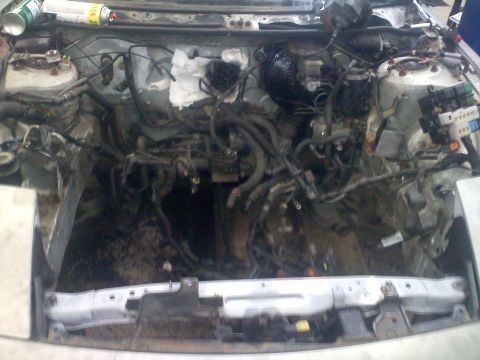 1993 Ford Probe - Disassembled engine bay of a car, showing exposed wiring and mechanical components.