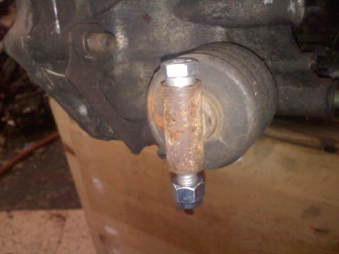 1993 Ford Probe - A close-up shows a rusty bolt and nut assembly on a vehicle's suspension component.