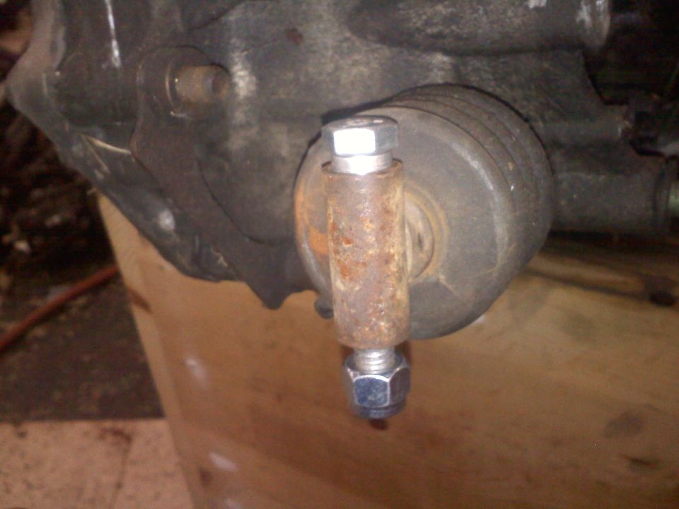 close-up of a rusty bolt and nut on a vehicle suspension part