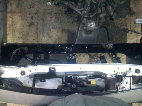 1993 Ford Probe - The front end of a vehicle is shown with exposed engine parts and wiring, suggesting it is undergoing maintenance or repair.