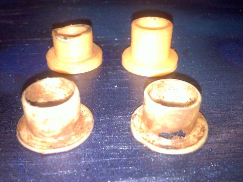 1993 Ford Probe - Four yellow bushings are shown on a dark, textured surface. The items appear to be automotive parts.