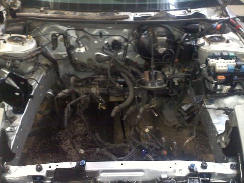 1993 Ford Probe - The engine bay of a car is shown with the engine removed, revealing various mechanical components.
