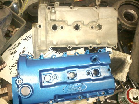 1993 Ford Probe - A blue Ford valve cover sits below a silver one, with handwritten notes visible in the background.
