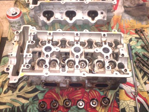 1993 Ford Probe - Disassembled engine cylinder heads and valve train components are laid out on a cloth, alongside a can of Mountain Dew.