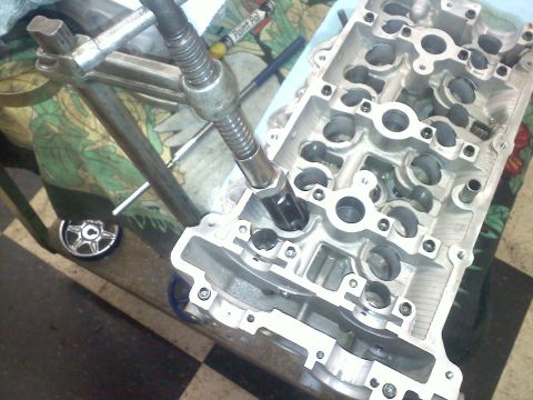 1993 Ford Probe - A tool is being used on an engine's cylinder head, likely for maintenance or repair.