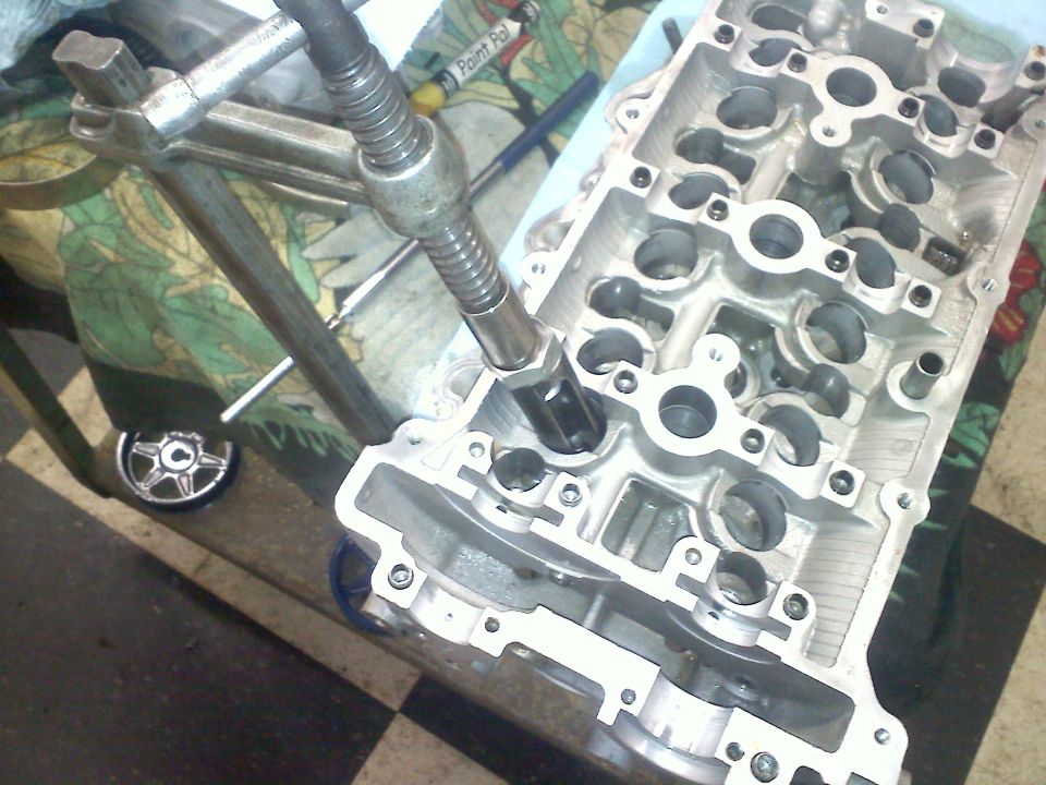 Tool inserted into engine cylinder head during repair