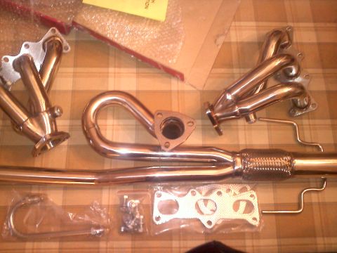 1993 Ford Probe - New exhaust components are arranged on a table, ready for installation.