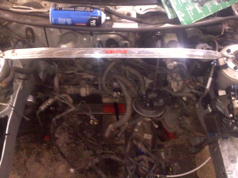 1993 Ford Probe - The engine bay is partially disassembled, showing various hoses and components. A strut bar is installed across the top.