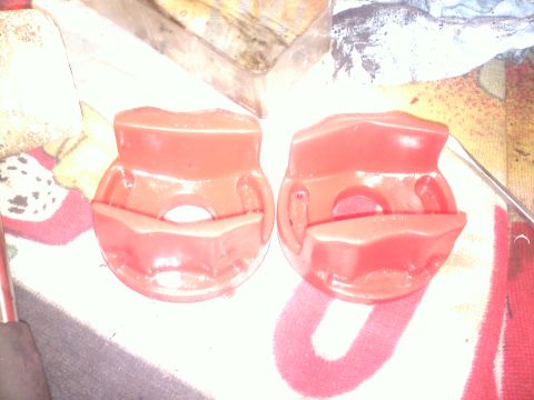 1993 Ford Probe - Two red suspension bushings are shown, resting on a patterned cloth surface.