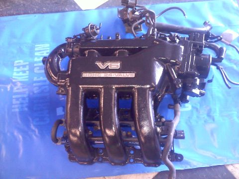 1993 Ford Probe - Engine part with V6 DOHC 24-valve labeling is shown on a blue tarp.