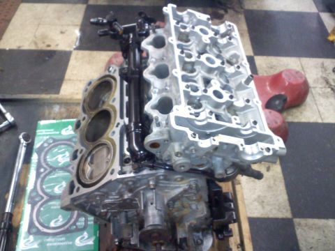 1993 Ford Probe - Disassembled engine components including block, pistons, and cylinder head are laid out for repair.