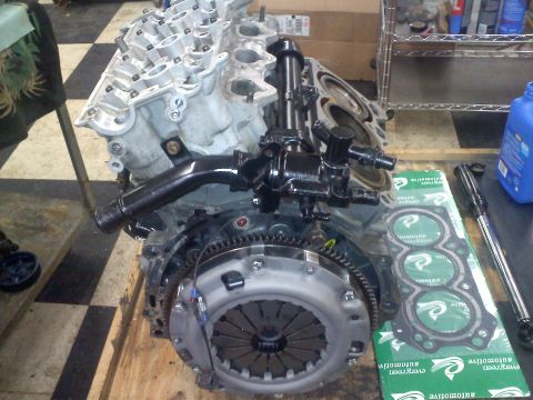 1993 Ford Probe - Engine block and clutch assembly with a gasket set nearby on a workbench.