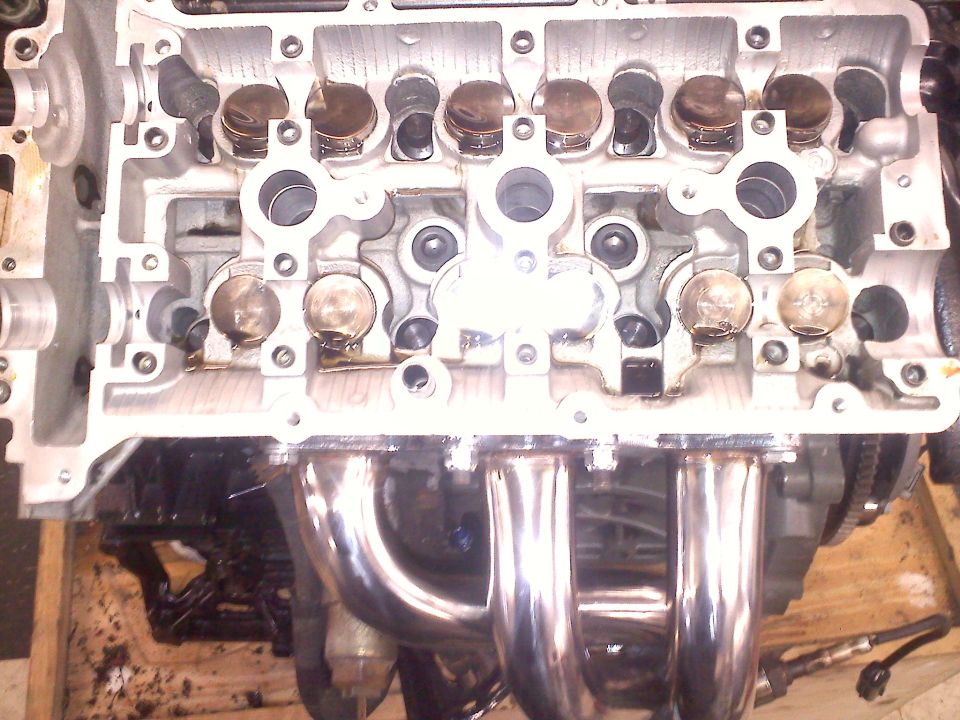 Close-up of an engine's cylinder head and exhaust manifold. Some valves are visible