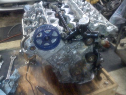 1993 Ford Probe - Engine components are visible on a workbench, with tools scattered around.