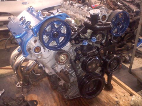 1993 Ford Probe - A V6 engine is shown with custom blue paint on the valve covers and pulleys, and chrome exhaust headers.