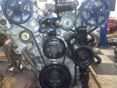 1993 Ford Probe - Close-up view of an engine's internal components, including pulleys, belts, and exhaust system.