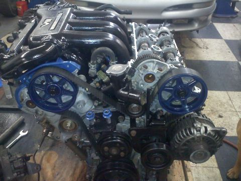 1993 Ford Probe - Engine components with blue accents and a partially visible car front in the background.