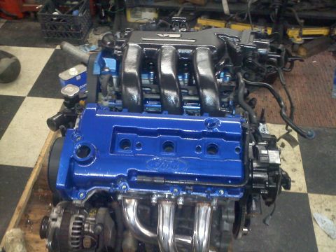 1993 Ford Probe - Engine assembly with blue valve covers and chrome exhaust headers.