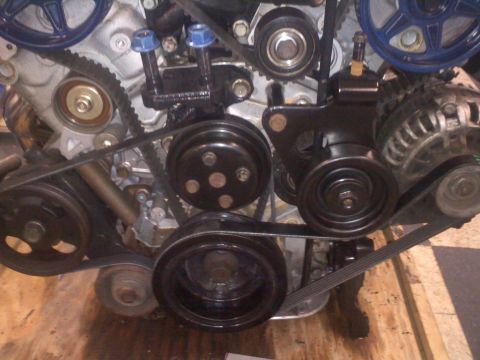 1993 Ford Probe - Close-up view of an engine's belt and pulley system, showing various components.