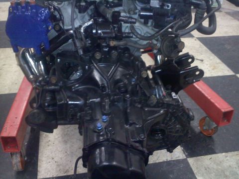 1993 Ford Probe - Engine and transmission assembly on a red engine stand, ready for installation or work.