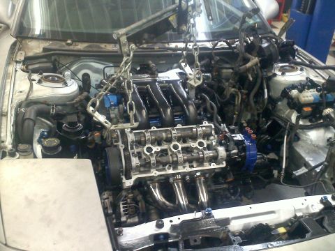 1993 Ford Probe - Engine removal in progress, showing the internal components and the lifting apparatus.