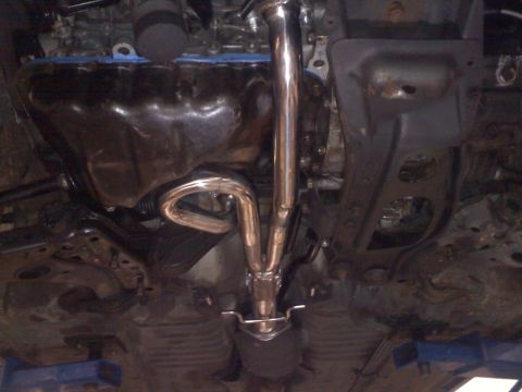 1993 Ford Probe - A close-up view of a vehicle's exhaust system and oil pan, with visible shiny metal pipes.