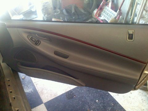 1993 Ford Probe - Interior view of a car door panel, tan upholstery and a red accent trim line.