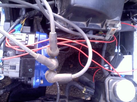 1993 Ford Probe - Close-up view of engine ignition components, including spark plug wires and a blue ignition coil.