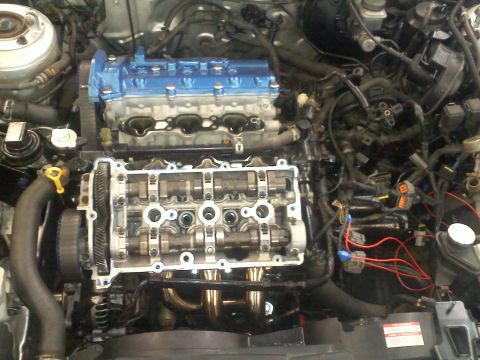 1993 Ford Probe - Disassembled engine bay with valve cover off, revealing internal engine components.