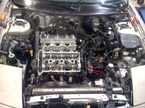 1993 Ford Probe - The engine bay of a car is shown with the valve covers removed, revealing internal engine components.