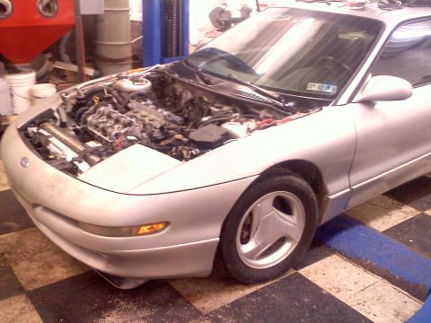1993 Ford Probe - Silver 1993 Ford Probe GT coupe with its hood open, revealing the engine bay, parked indoors.