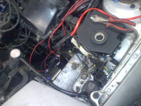 1993 Ford Probe - Tools and electrical components are visible in the engine bay of a car.