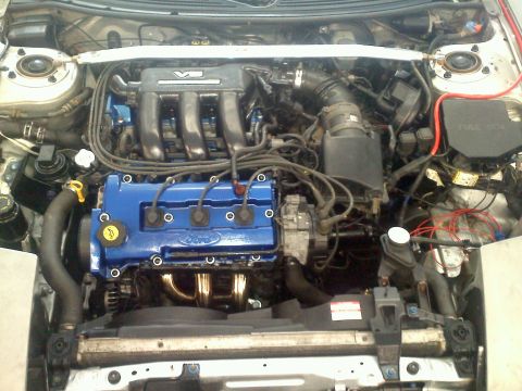 1993 Ford Probe - Close-up view of a car's engine bay, showing the valve covers and exhaust manifold.
